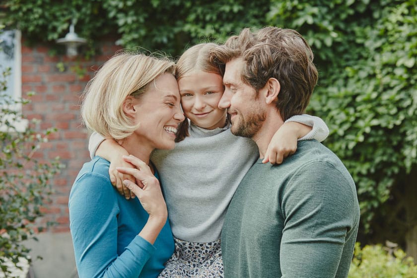 Glückliche Familie vor ihrer Immobilie in Cottbus